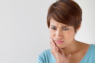 woman holding jaw | Dentist Aurora IL