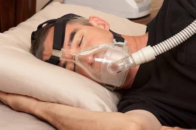 man with sleep apnea mask | Dentist Aurora il