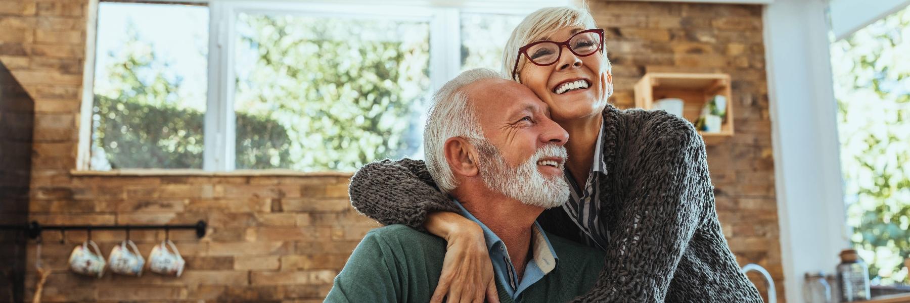 Couple smiling after getting dental implants in Aurora, IL