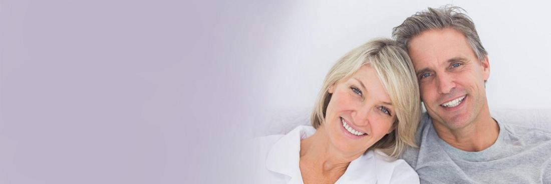 Couple smiling after getting dental implants in Aurora, IL 