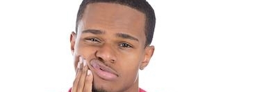 Man holding his jaw due to a dental emergency in Aurora, IL