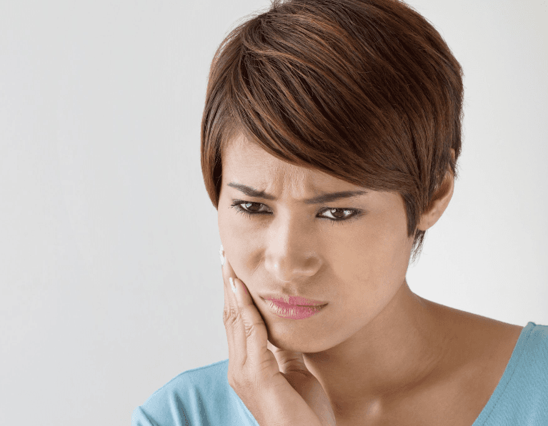 Lady holding her jaw due to a dental emergency in Aurora, IL