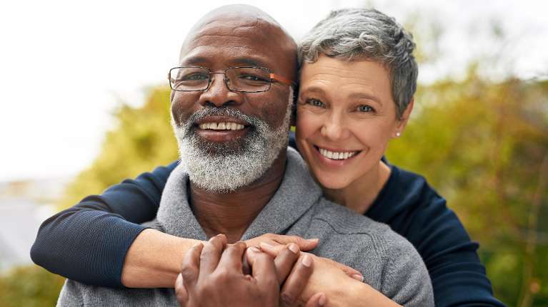 Happy couple smiling with bright, healthy teeth, showcasing excellent dental care and oral hygiene.