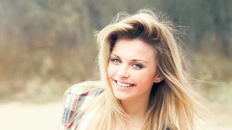 A woman smiling after getting Dental Implants in Aurora, IL